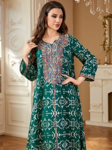 Détail de la broderie colorée et des paillettes sur robe kaftan ethnique vert foncé