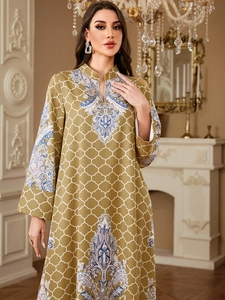 Detail of bohemian olive green kaftan with intricate paisley prints and geometric patterns