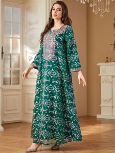 Détails de la robe caftan vert foncé avec paillettes colorées et broderies de luxe