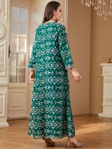 Détail d'une robe caftan vert foncé avec motifs géométriques et broderies sur les poignets