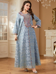 Détails de broderies multicolores et de paillettes sur une robe kaftan bleu clair