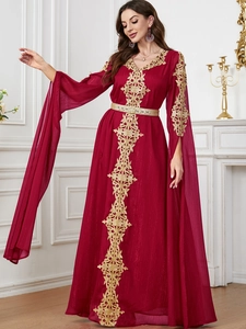 Detail eines weinroten marokkanischen Kaftans mit Goldstickerei und dekorativem Metallgürtel