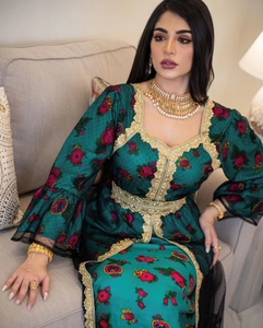 Detail of emerald green dress with gold embroidery and lace trim on the sleeves