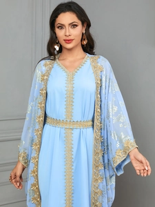 Close-up of light blue kaftan with intricate gold embroidery on chiffon fabric