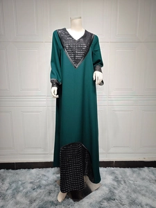 Detailed close-up of dark green long sleeve maxi dress with black sequin embroidery