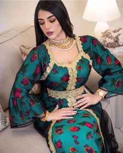Detail of green kaftan dress with gold embroidery and sheer mesh sleeve patchwork