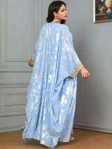 Detail of light blue kaftan dress with gold floral print and embroidery on the cuffs