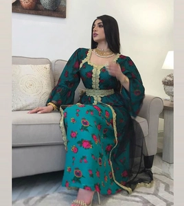 Detail of green floral kaftan featuring intricate gold embroidery and a matching waist belt