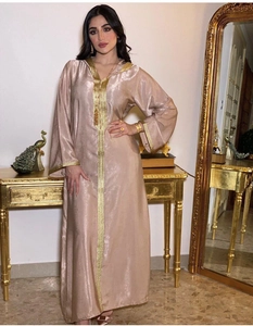 Close-up of golden embroidery details on champagne hooded velvet kaftan dress sleeve