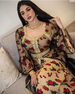 Detail of floral embroidery and gold lace trim on ethnic kaftan mesh dress