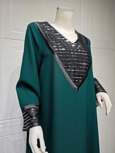 Detailed view of sequin embroidery on V-neckline of dark green long ethnic dress
