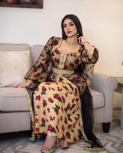 Detailed view of golden embroidery on mesh kaftan dress with red floral prints