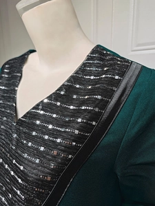Detail of V-neckline with silver sequins and beadwork on a dark green ethnic dress