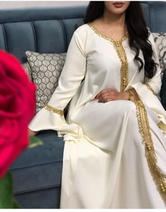 Detail of elegant gold embroidery on white lotus sleeve kaftan with refined golden floral lace