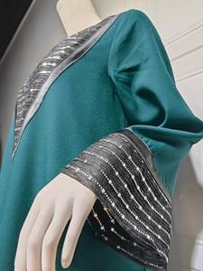 Detail of silver sequin embroidery on sleeves and collar of dark green ethnic dress