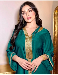 Detail of dark teal kaftan with intricate gold embroidery and elegant long sleeves