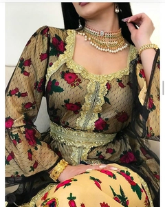 Close-up of golden embroidery and red floral patterns on mesh ethnic dress detail