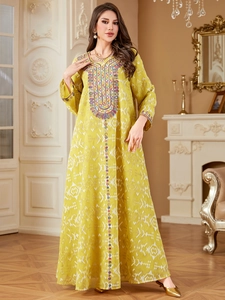 Robe longue ethnique vert moutarde avec broderies bohèmes et imprimés géométriques chic