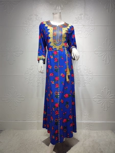 Close-up of royal blue kaftan dress featuring gold embroidery and pink floral patterns