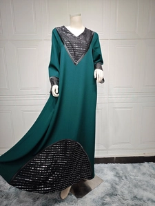 Detail of dark green dress with silver sequin embroidery on V-neck and sleeve cuffs