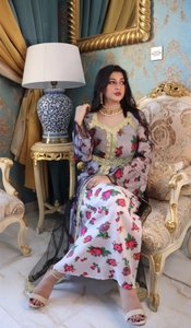 Detail of floral printed mesh dress with gold embroidery and luxury accessories