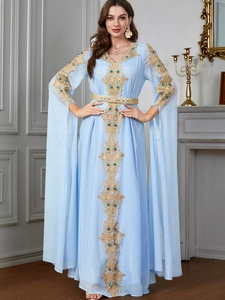 Makroaufnahme der hellblauen Kaftan-Robe mit Goldstickerei und luxuriösen Edelsteinen