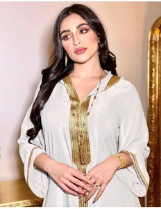 Detailed embroidery on the collar and cuffs of a luxurious champagne velvet hooded kaftan