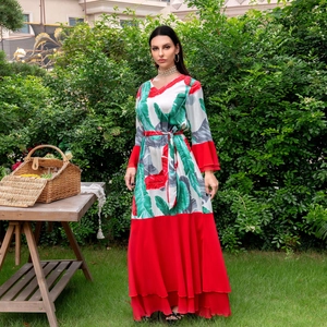 Détail de la robe à imprimé palmier tropical avec col en V et jupe rouge à volants