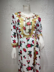 Detail of floral Jalabiya dress with golden sequin embroidery and tasseled gold belt