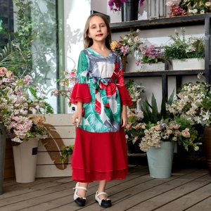 Détail de robe rouge pour fille avec motif tropical et manches à volants superposés