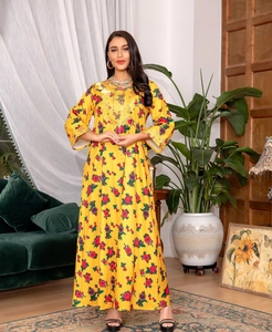 Detail of yellow floral maxi dress featuring intricate gold sequin embroidery on neckline