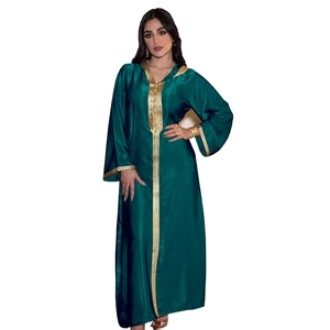 Close-up of golden embroidery details on dark green satin hooded kaftan dress fabric
