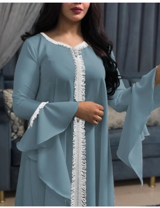 Detail of teal kaftan dress with white lace embroidery and flared bell sleeves