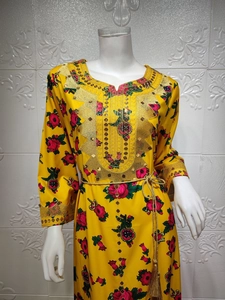 Detail of yellow floral dress showing gold sequin embroidery and tassel belt design
