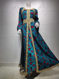 Detail of blue kaftan dress showing golden lace embroidery and floral print patterns