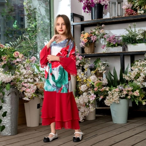 Détails d'une robe rouge pour filles avec imprimé tropical et manches à volants étagés