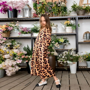 Girl's leopard print long dress with gold lace trim and elegant floral studio background