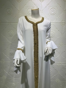Detail of white long-sleeved abaya featuring gold embroidery and flared lotus sleeves