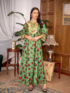 Detail of floral green kaftan dress featuring gold embroidery on the neckline and cuffs