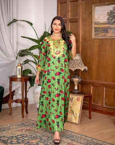 Close-up of ethnic green Jalabiya dress featuring gold embroidery and floral prints