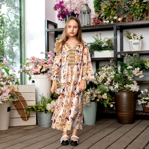 Détails de la bordure dorée et des motifs floraux sur la robe Abaya à manches longues fille