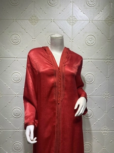 Detail of the champagne velvet hooded dress with exquisite embroidery and sphere buttons
