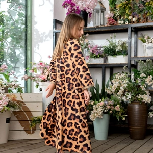 Detailed view of leopard print girl dress with gold lace cuffs in a garden setting