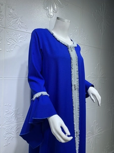 Detail of royal blue dress featuring elegant silver lace embroidery and bell sleeves