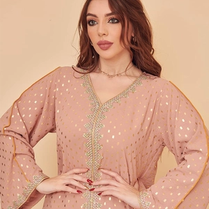 Detail eines Kaftan-Kleids mit V-Ausschnitt, goldenen Punkten und Ethno-Stickerei