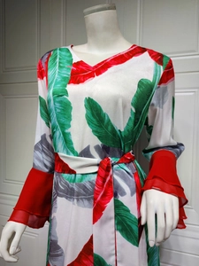 Détail de la robe à imprimé tropical avec poignets à volants rouges et ceinture