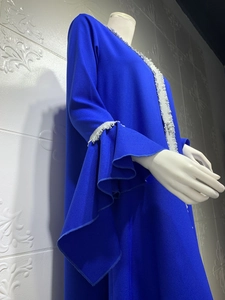 Detail of dark blue kaftan showing layered ruffle sleeves and white lace embroidery trim