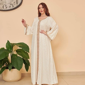 Detail der weißen Abaya mit goldenen Punkten und Wellenstickerei am Halsausschnitt