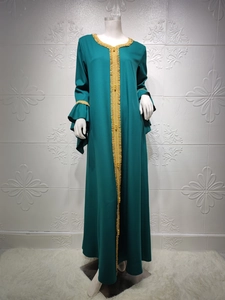 Detail of gold floral embroidery and beaded trim on dark green lotus sleeve kaftan dress
