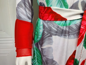 Détail de robe à imprimé tropical avec ceinture rouge et poignets à volants